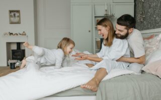 Genitori e bimba felici sul letto