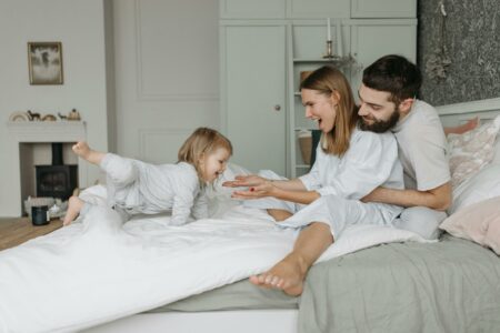 Genitori e bimba felici sul letto