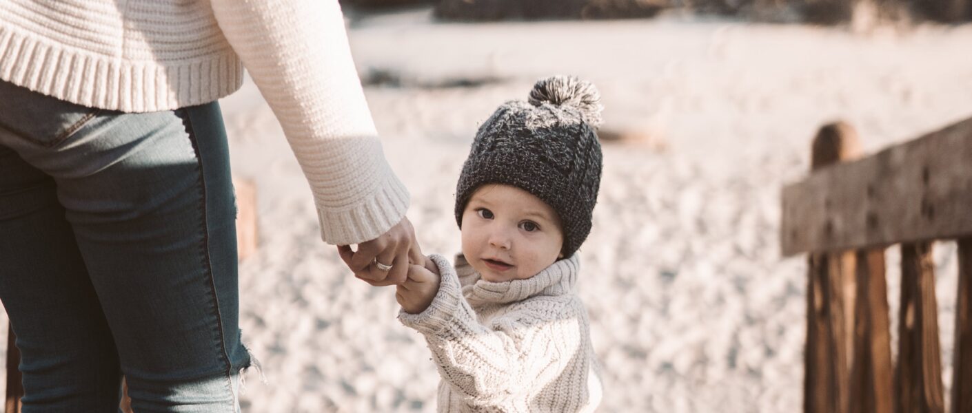 mamma e bambino in spiagga in inverno